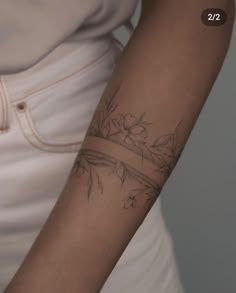 a woman's arm with a flower tattoo on the left side of her arm