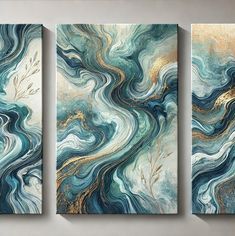 three abstract paintings in gold, blue and teal colors on a wall with white walls