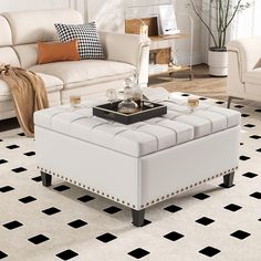 a living room with white furniture and black and white flooring