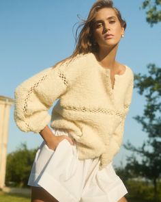 a woman in white shorts and a sweater