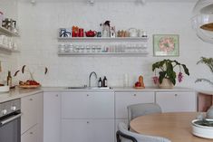 the kitchen is clean and ready to be used for cooking or baking, with dishes on the shelves above the sink