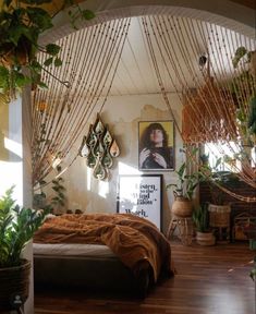 a bedroom with plants and pictures on the wall