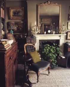 a living room filled with furniture and a fire place in front of a mirror on the wall