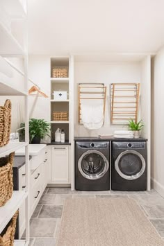 a washer and dryer sitting in a room next to each other with towels hanging on the rack