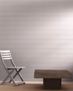 a white chair sitting next to a wooden bench in front of a wall with planks