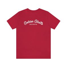 Show off your Johnson County pride in this Golden Ghetto tee. This classic unisex jersey Bella+Canvas short sleeve tee fits like a well-loved favorite. Soft cotton and quality print make users fall in love with it over and over again. These t-shirts have-ribbed knit collars to bolster shaping. The shoulders have taping for better fit over time. Dual side seams hold the garment's shape for longer. * 100% Airlume combed and ringspun cotton (fiber content may vary for different colors) * Light fabr Graphic Tee T-shirt With Team Name For Summer, Summer Graphic Tee With Team Name, Cotton Graphic Tee T-shirt With Team Name, Graphic Tee Cotton T-shirt With Team Name, Graphic Tee T-shirt With Team Name In Cotton, Graphic Tee With Team Name In Cotton, Retro Cotton T-shirt With Team Name, Casual Tri-blend T-shirt With Team Name, Casual Team Name T-shirt