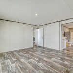 an empty room with wood floors and white walls