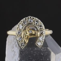 Description:Channel your love for horses and elegance with this unique vintage horse shoe ring. Crafted from 14K yellow gold, this 4.68-gram ring showcases a stunning horse head design encircled by a horseshoe adorned with 12 round-cut diamonds. These J-colored diamonds total 0.48 carats with I1 clarity, adding sparkle and character to this equestrian-themed piece. A perfect blend of charm and sophistication, this ring is a true statement for any jewelry lover. Specifications: Metal: 14K Yellow Horse Shoe Ring, Groom Accessories, Gold Horse, Horse Shoe, Head Design, Gold Art Deco, Vintage Horse, Cz Pendant, Bridal Bands