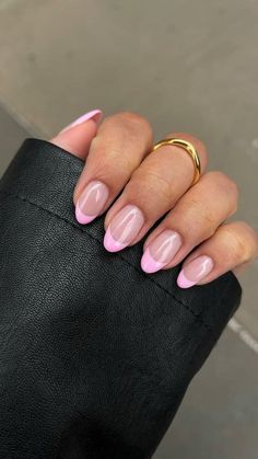 a woman's hand with pink and black manies on her nails, wearing a gold ring