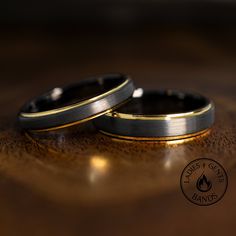 two wedding rings sitting on top of a wooden table