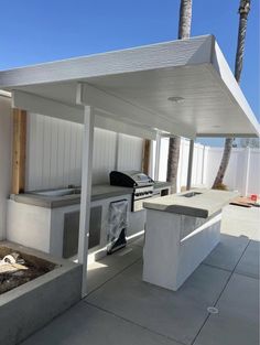 an outdoor bbq and grill area with palm trees in the background