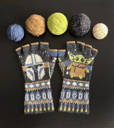 four balls of yarn and two mittens on a table