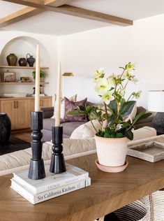 a living room filled with furniture and a wooden table topped with a potted plant