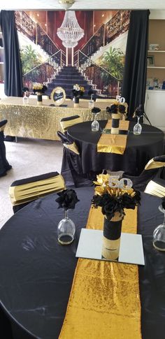 a black table with gold runner and centerpieces