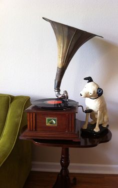 a dog sitting on top of a table next to a record player