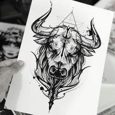 a person holding up a drawing of a bull with horns and triangles on its head