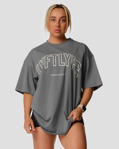 A female athlete is in a gray oversized T-shirt with a large lyftlyfe logo on the chest. Pump Cover, Ultimate Workout, T Shirt Oversized, Oversized T Shirt, Workout Tee, Oversized Tshirt, Stretch Cotton, Crew Neckline, Cement