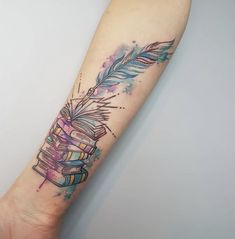 a watercolor tattoo with books and an arrow on the left arm that is painted blue