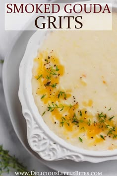 a white bowl filled with mashed potatoes and garnished with herbs