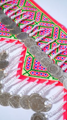 some silver coins and beads on a table