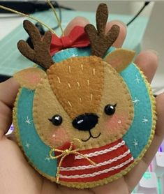 a hand holding an ornament with a deer on it