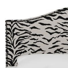 a zebra print headboard with white sheets and black trimmings on the top