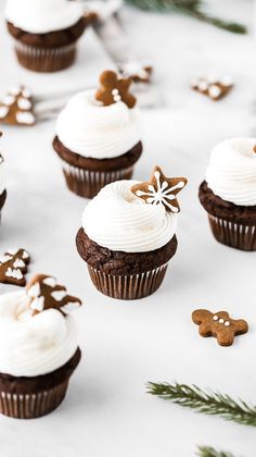 cupcakes with white frosting and gingerbread decorations