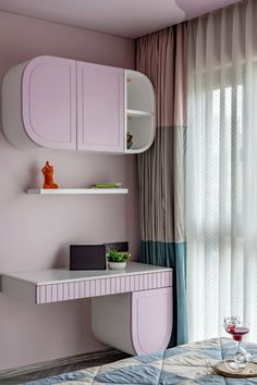 a bedroom with a desk and shelves in it, next to a window that has sheer curtains