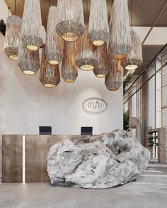 a large rock sitting in the middle of a room with chandeliers hanging from it