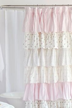 a shower curtain with pink and white ruffled curtains