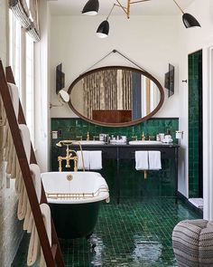 a bathroom with green tile and gold fixtures