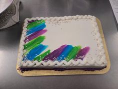 a cake with white frosting and colorful icing