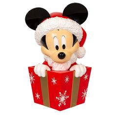 a mickey mouse figurine sitting on top of a red box with snowflakes