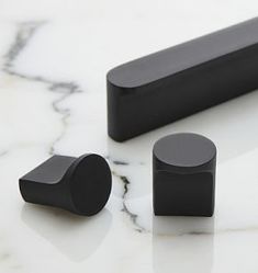 three black objects sitting on top of a white counter