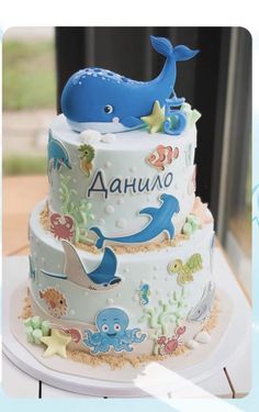 a blue whale is on top of a three tiered cake with under the sea theme