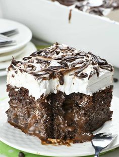 a piece of chocolate cake with white frosting and chocolate swirls on top, sitting on a plate