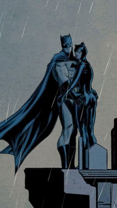 batman and catwoman standing on top of a building in the rain with city lights behind them