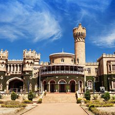 a large castle like building with a clock tower in the center and steps leading up to it