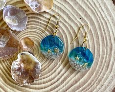 three different types of earrings sitting on top of a wooden table