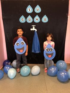 two young children standing in front of balloons