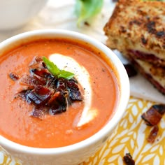 two bowls of tomato soup with toasted bread on the side and garnished with basil