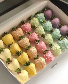 a box filled with lots of different colored strawberries