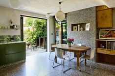 a dining room table and chairs in front of a sliding glass door that leads to an outside patio