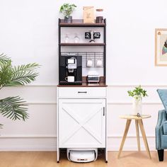 a room with a blue chair and a white cabinet on the floor next to a potted plant