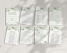 the wedding programs are laid out on top of each other, with green leaves and foliage