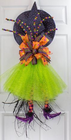 a door hanger with a green tutu skirt and purple shoes hanging on it