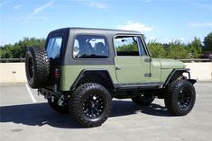 a green jeep parked in a parking lot