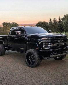 a large black truck parked on top of a road