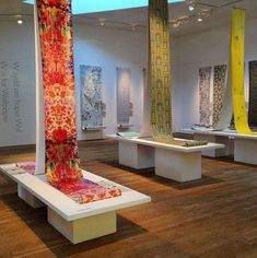 a room filled with lots of different types of art on display in white pedestals