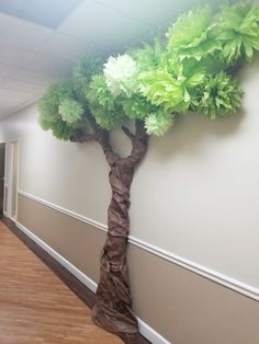 a paper tree on the wall in an office hallway with wood floors and hard wood flooring